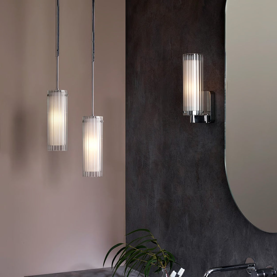 Pair of Astro Ottavino pendants over a vanity, polished chrome with ribbed glass
