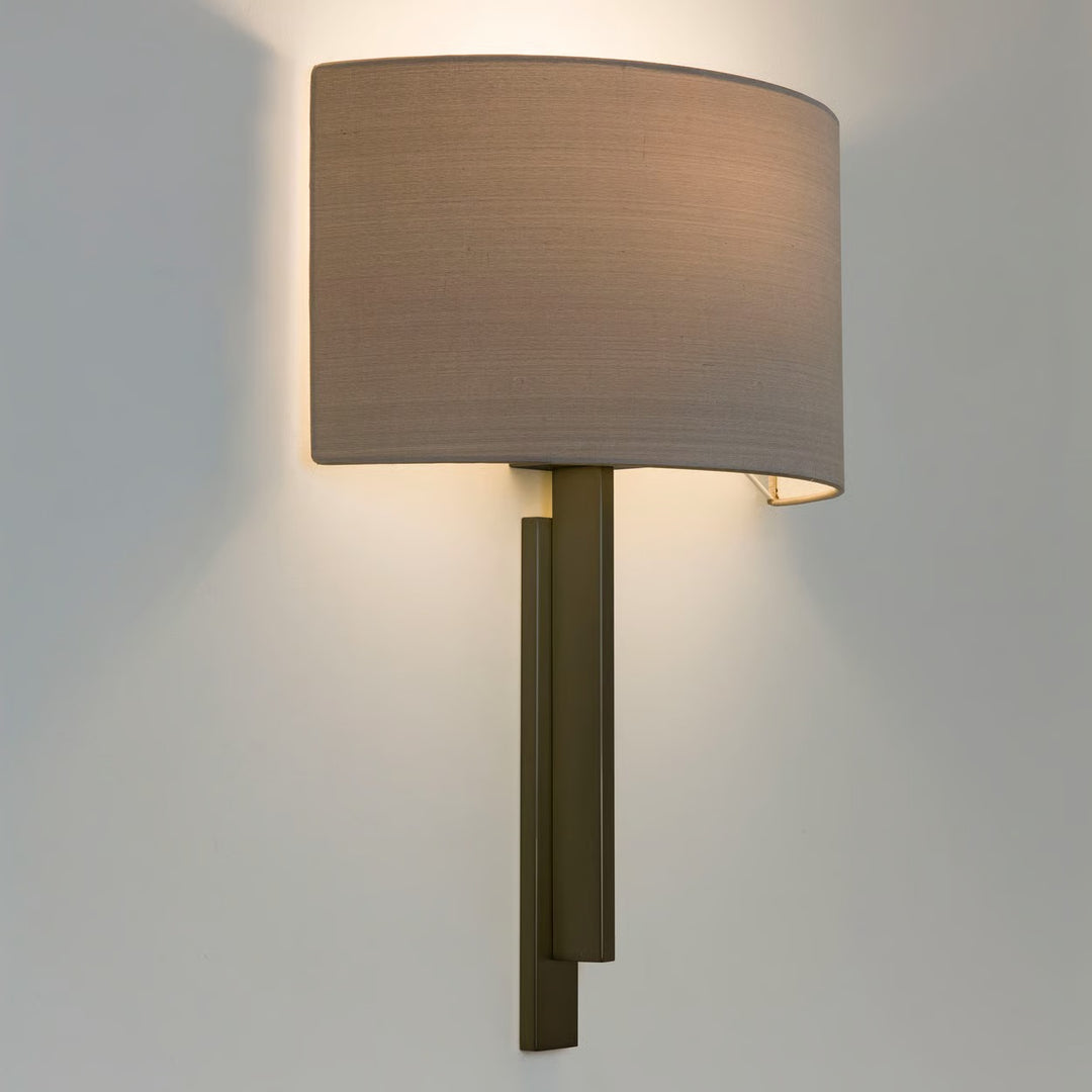 Close-up of Tate wall light in matt gold finish, highlighting the metal stem and curved shade