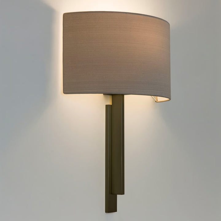 Close-up of Tate wall light in matt gold finish, highlighting the metal stem and curved shade